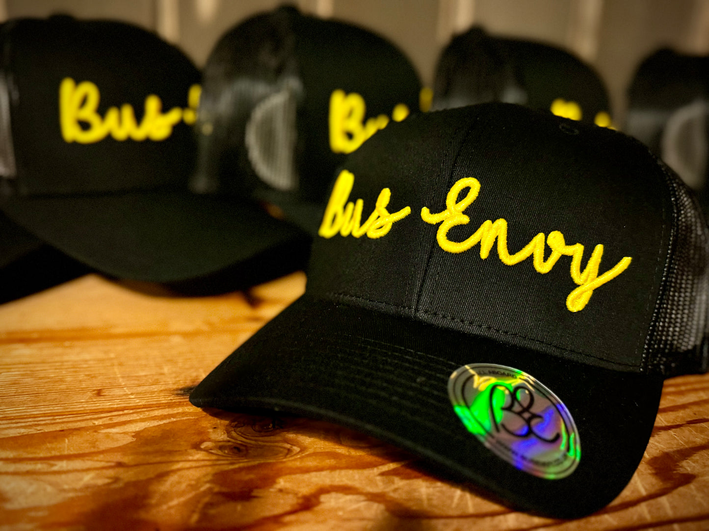 Snap Back Trucker Cap. All black. Yellow 3D logo.