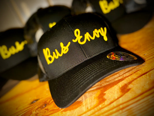 Snap Back Trucker Cap. All black. Yellow 3D logo.